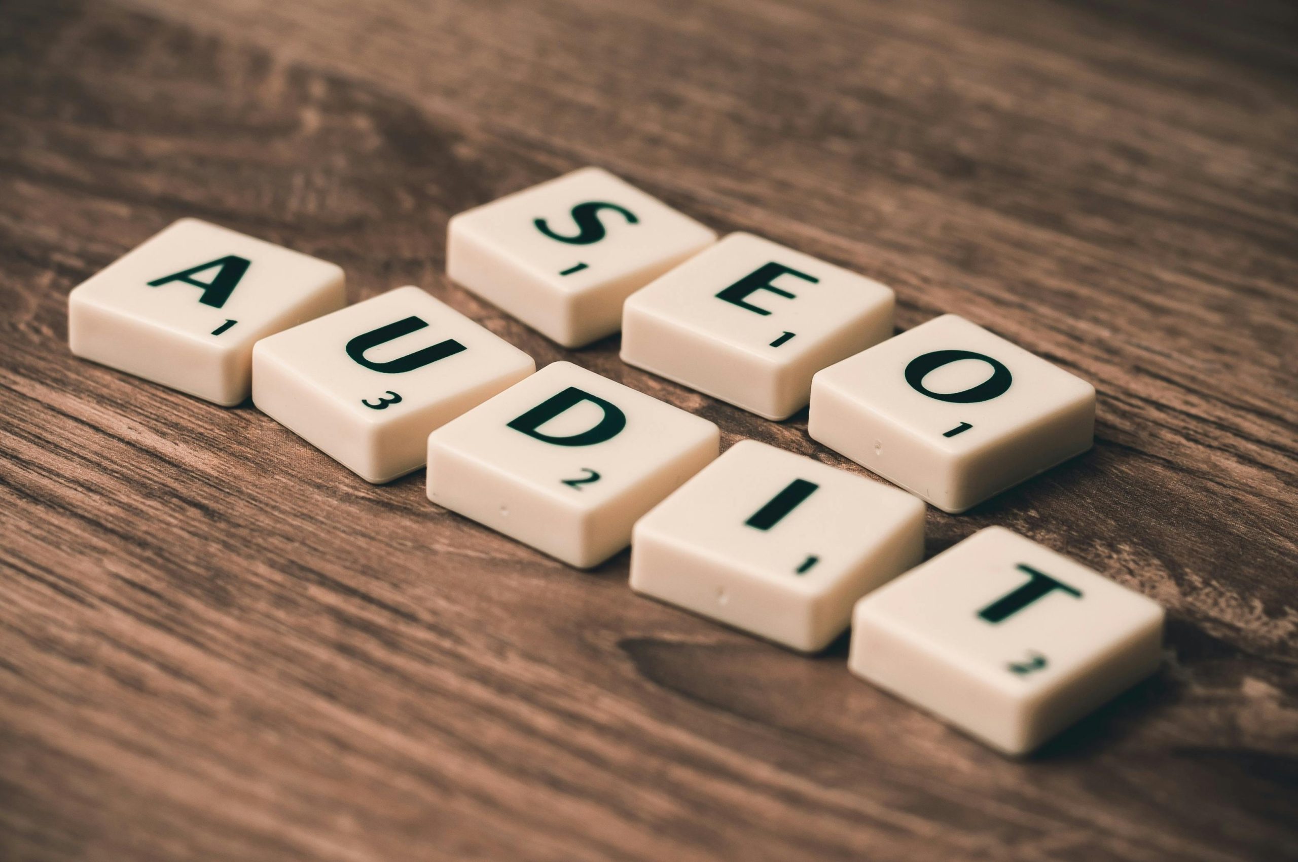 Letters spelling out SEO Audit on a wooden table.